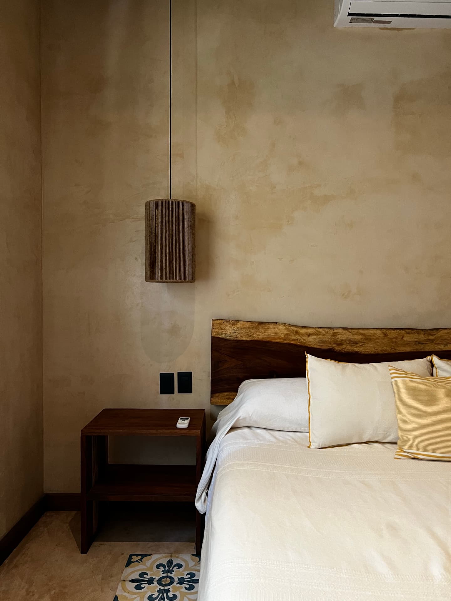 Warm plaster bedroom with linen bedding and a timber headboard
