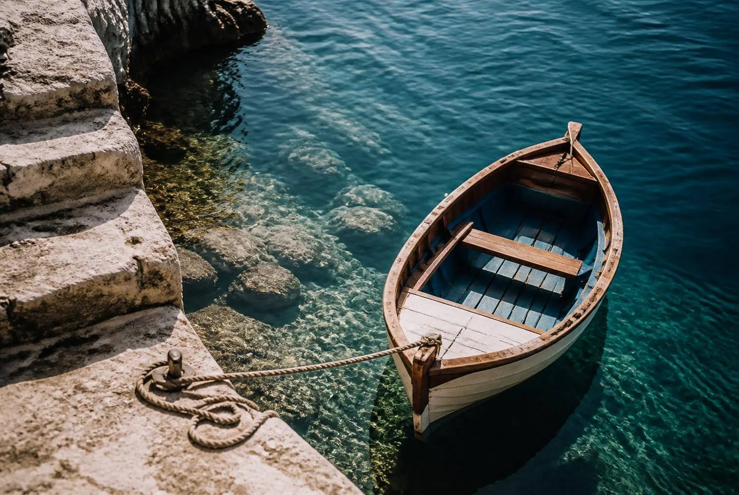 A small wooden boat moored in clear water