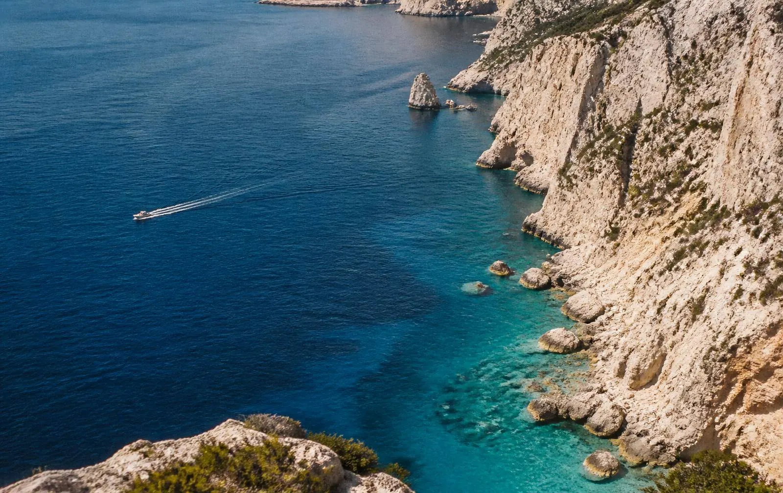 A coastal road curving above the sea in early light