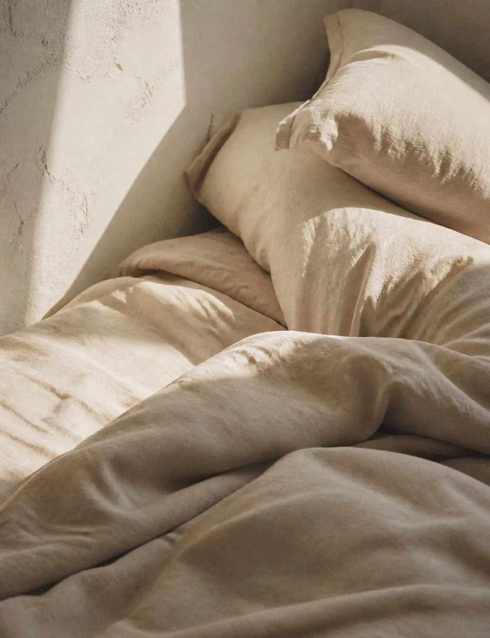 Morning light across linen in a quiet guest room